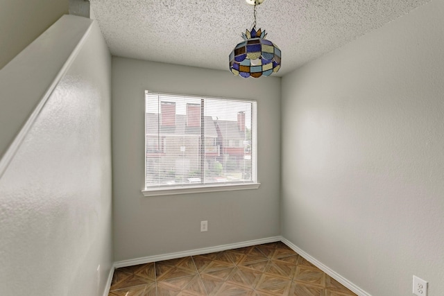 empty room with a textured ceiling and parquet floors