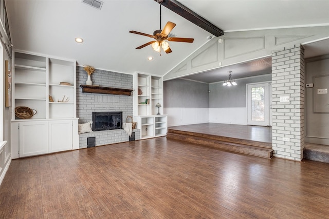 unfurnished living room with built in shelves, lofted ceiling with beams, a brick fireplace, dark hardwood / wood-style floors, and ceiling fan with notable chandelier