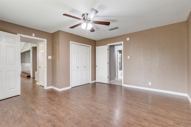 unfurnished bedroom featuring ceiling fan and dark hardwood / wood-style floors