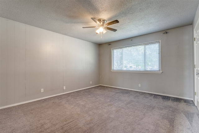 carpeted spare room featuring a textured ceiling and ceiling fan