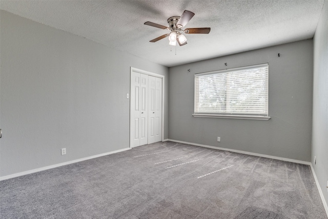 carpeted empty room featuring ceiling fan and a textured ceiling