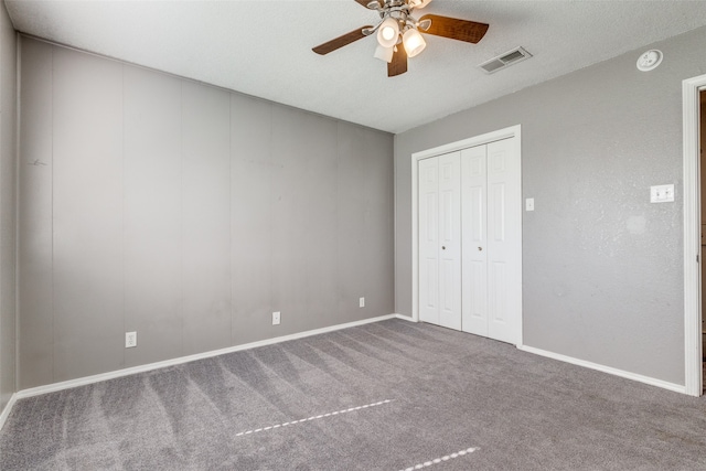 unfurnished bedroom with carpet flooring, a textured ceiling, ceiling fan, and a closet