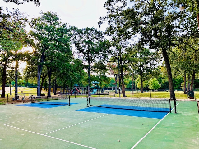 view of tennis court featuring a playground