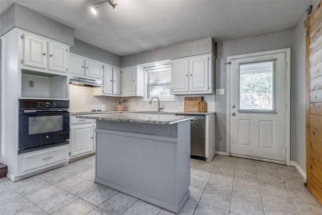 kitchen with white cabinets, black appliances, and a center island