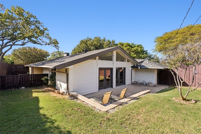 rear view of house featuring a lawn and a patio