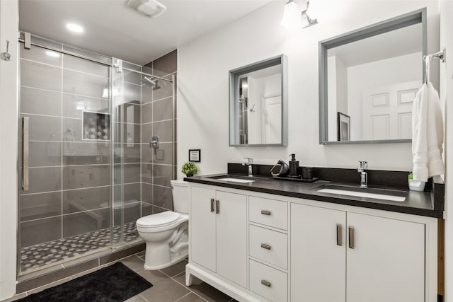 bathroom with tile patterned flooring, walk in shower, vanity, and toilet