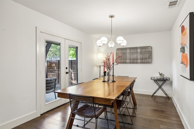 dining space with dark hardwood / wood-style floors, a chandelier, and french doors