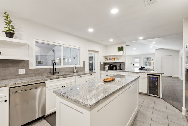 kitchen featuring dishwasher, wine cooler, sink, white cabinets, and a kitchen island