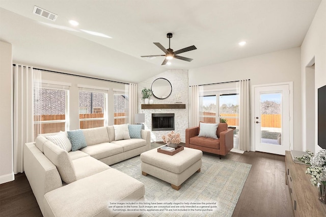 living room with dark hardwood / wood-style flooring, a stone fireplace, lofted ceiling, and ceiling fan