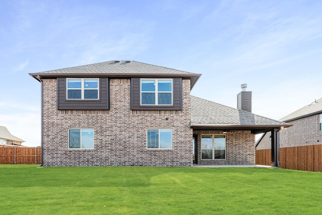 rear view of property featuring a lawn