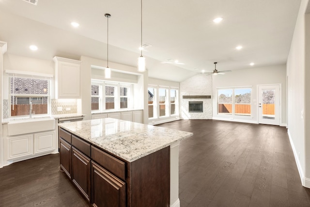 kitchen with dark wood-type flooring, dark brown cabinetry, sink, hanging light fixtures, and backsplash