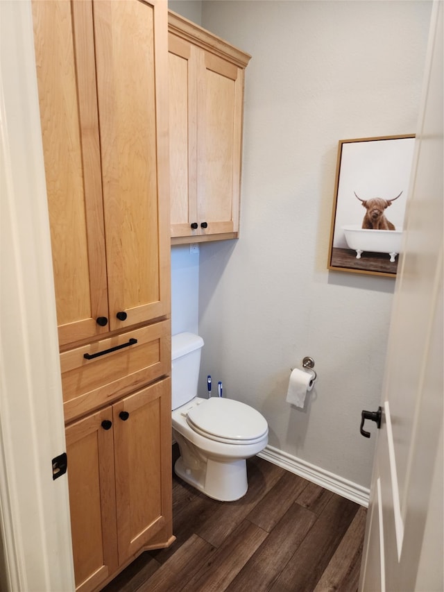 bathroom with hardwood / wood-style flooring and toilet