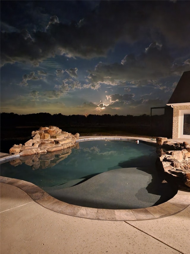 view of pool at dusk