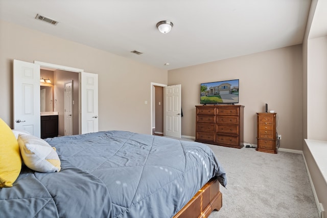 bedroom featuring ensuite bath and light colored carpet