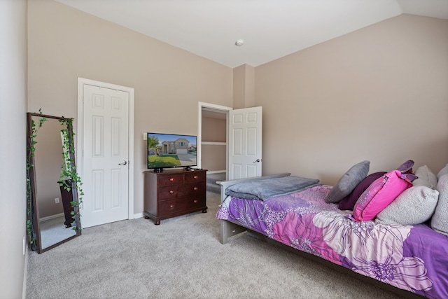 bedroom with lofted ceiling and light colored carpet