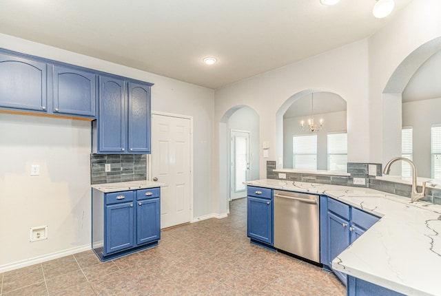 kitchen featuring blue cabinetry, sink, light stone counters, stainless steel dishwasher, and a notable chandelier