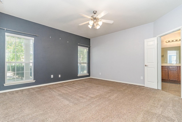 unfurnished room with ceiling fan, a healthy amount of sunlight, and light colored carpet