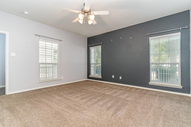 carpeted empty room featuring ceiling fan and a healthy amount of sunlight