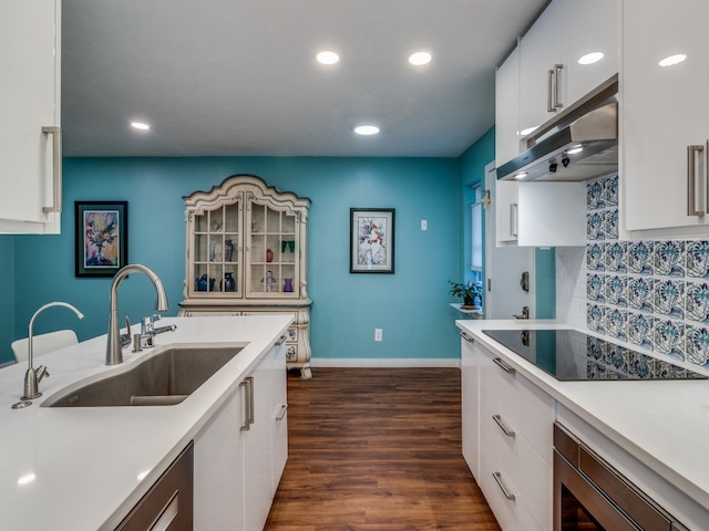 kitchen with dark hardwood / wood-style floors, sink, white cabinetry, backsplash, and black electric cooktop