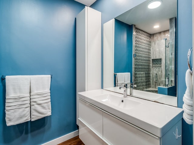 bathroom featuring vanity, hardwood / wood-style floors, and a shower with shower door