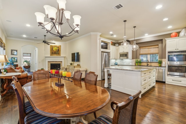 dining area with dark hardwood / wood-style floors, ornamental molding, and a wealth of natural light