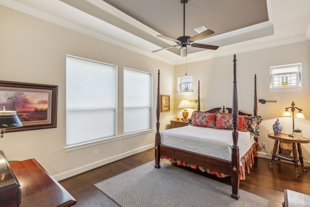 bedroom featuring a tray ceiling, ceiling fan, dark hardwood / wood-style floors, and crown molding