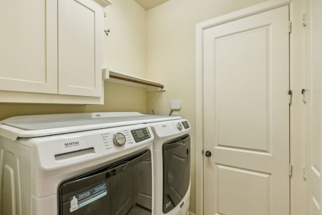 laundry area featuring washer and clothes dryer and cabinets