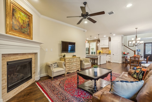 living room with ceiling fan with notable chandelier, ornamental molding, and dark hardwood / wood-style floors