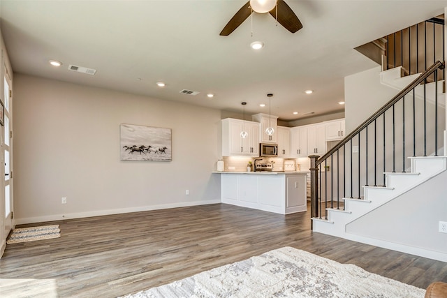 living room featuring ceiling fan and hardwood / wood-style floors