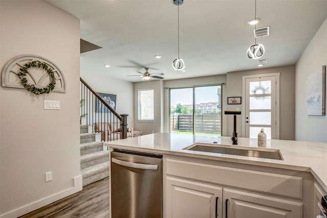 kitchen with white cabinetry, dishwasher, pendant lighting, light stone counters, and sink