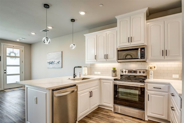 kitchen featuring white cabinetry, stainless steel appliances, and kitchen peninsula