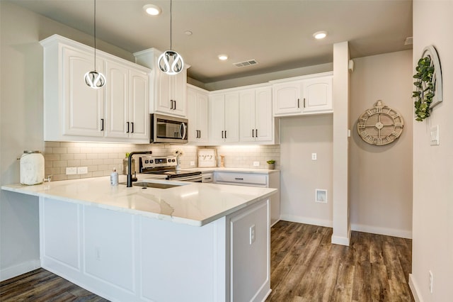 kitchen featuring hanging light fixtures, kitchen peninsula, stainless steel appliances, and white cabinetry