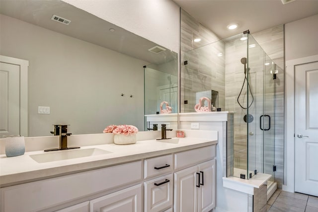 bathroom with walk in shower, vanity, and tile patterned flooring