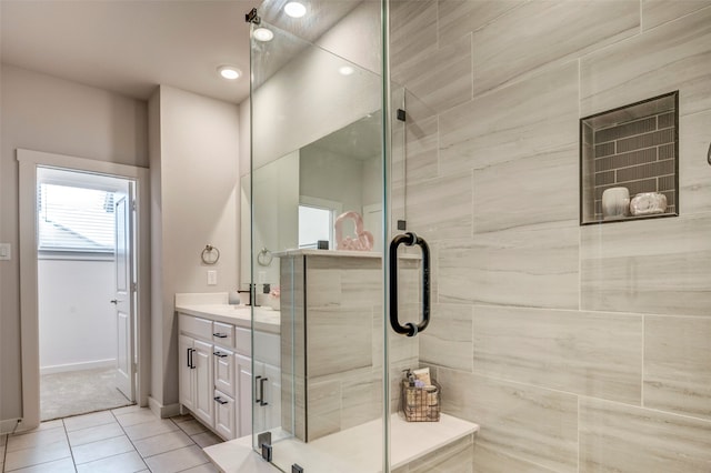 bathroom featuring tile patterned floors, a shower with shower door, and vanity