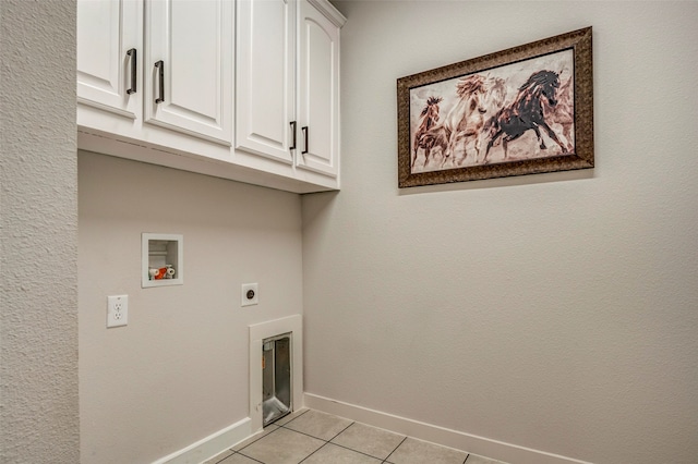 clothes washing area featuring light tile patterned floors, washer hookup, electric dryer hookup, and cabinets