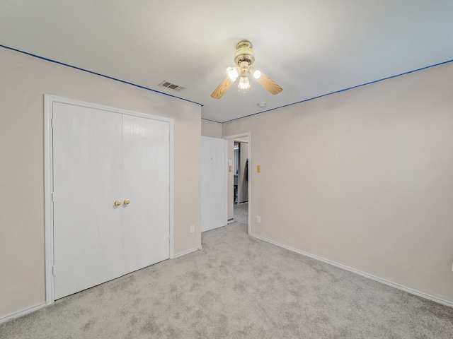 unfurnished bedroom with ceiling fan, light colored carpet, and a closet