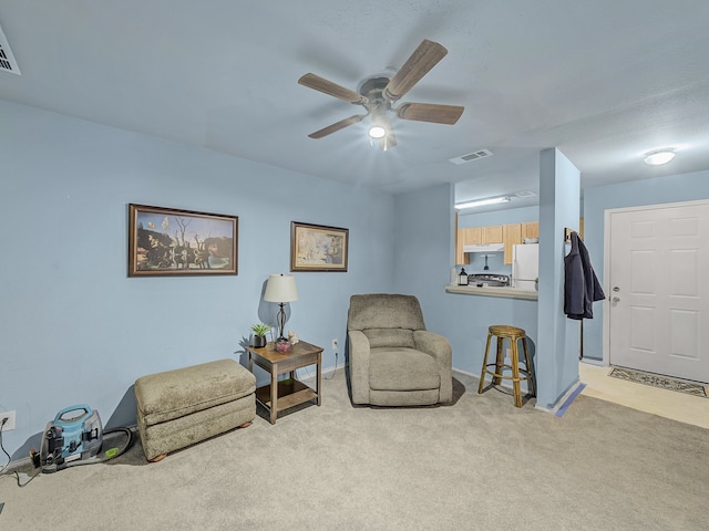 living area featuring ceiling fan and light colored carpet