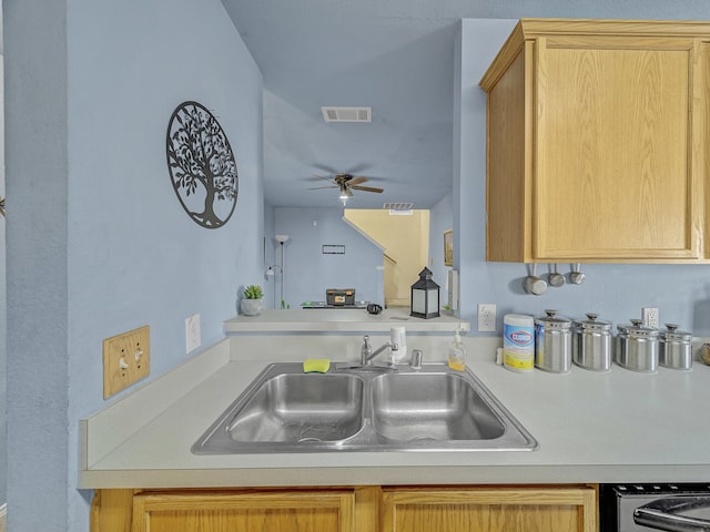 kitchen with ceiling fan, light brown cabinetry, and sink