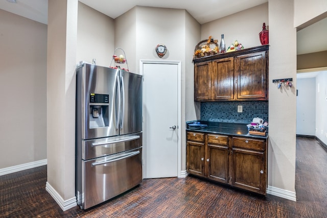 kitchen featuring dark brown cabinetry, stainless steel refrigerator with ice dispenser, dark wood-type flooring, and decorative backsplash