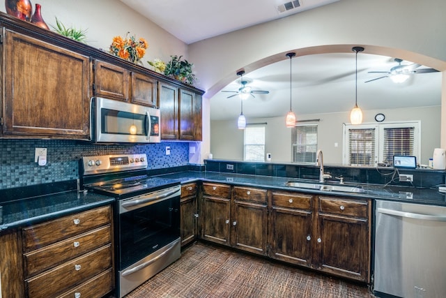 kitchen featuring stainless steel appliances, dark brown cabinets, ceiling fan, decorative light fixtures, and sink