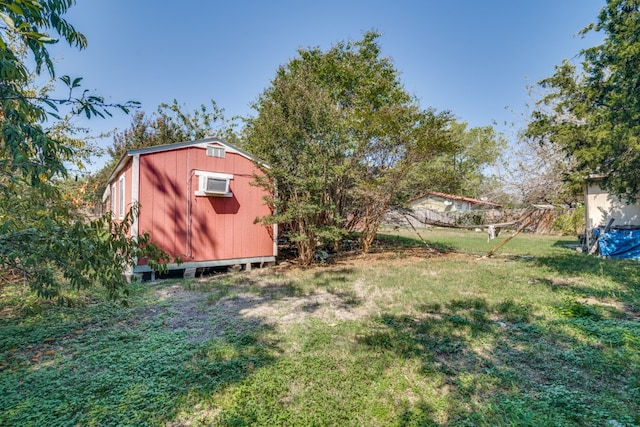 view of yard featuring a storage unit and a wall mounted AC