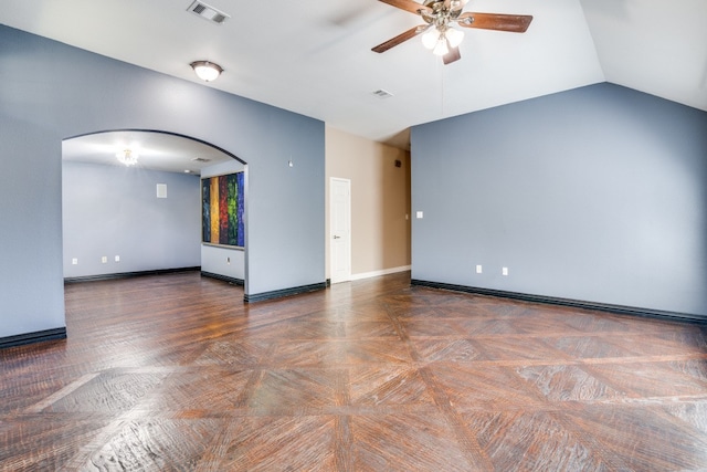 empty room with vaulted ceiling, ceiling fan, and dark parquet flooring