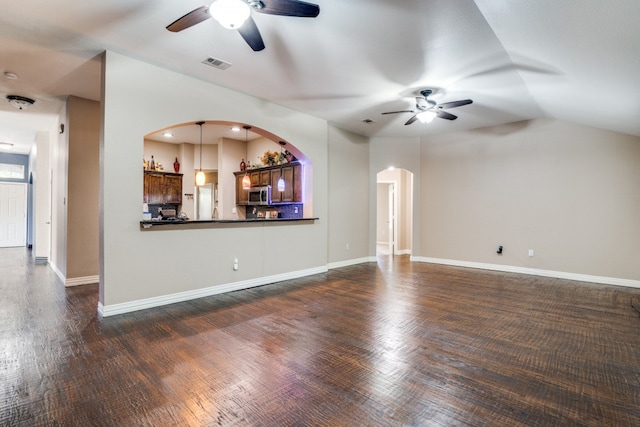 unfurnished living room with vaulted ceiling, ceiling fan, and dark wood-type flooring