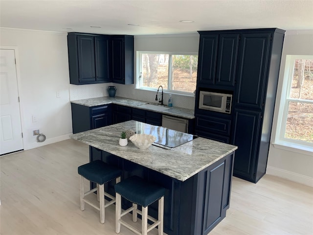 kitchen featuring a wealth of natural light, appliances with stainless steel finishes, a kitchen breakfast bar, and a sink