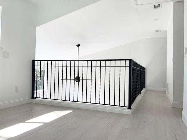 hall featuring baseboards, lofted ceiling, and wood finished floors