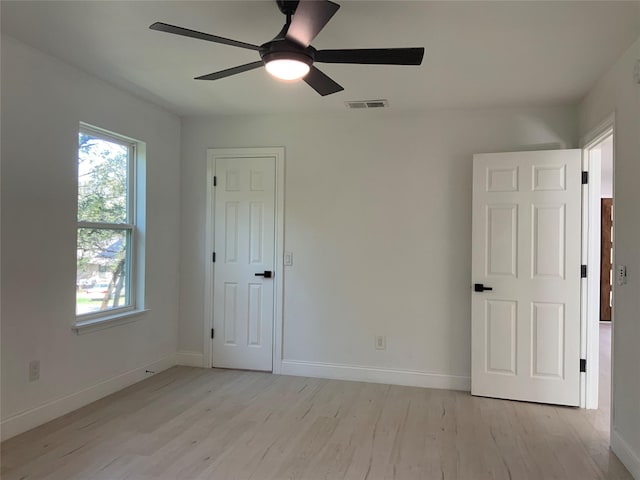 unfurnished bedroom featuring visible vents, baseboards, light wood-style floors, and a ceiling fan