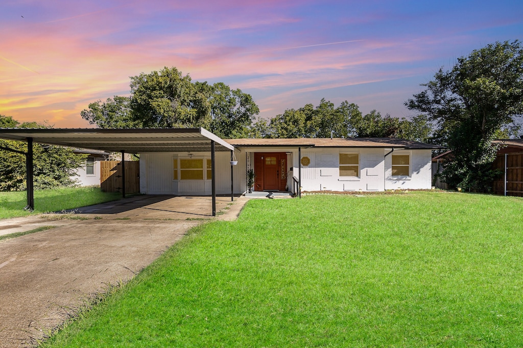 ranch-style house with a yard and a carport