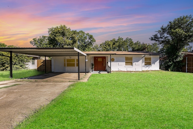 ranch-style house with a yard and a carport