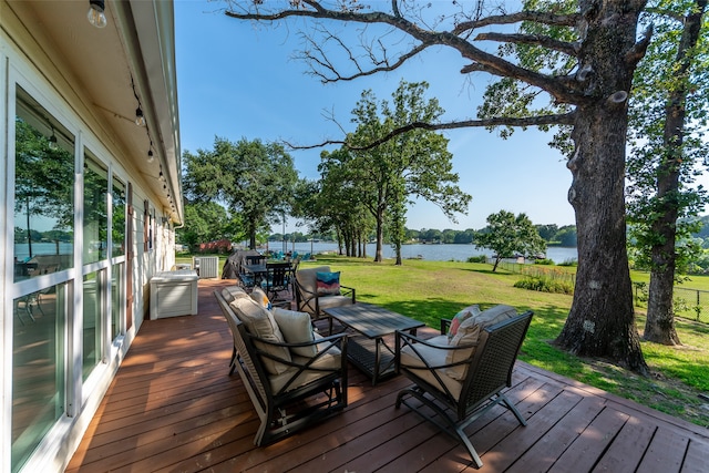 wooden terrace with a water view and a yard