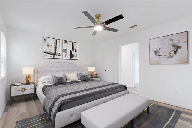 bedroom featuring multiple windows, ceiling fan, and hardwood / wood-style flooring